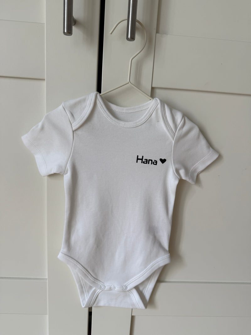 Personalisierter Baby-Body aus Bio-Baumwolle mit dem Namen für Neugeborene.