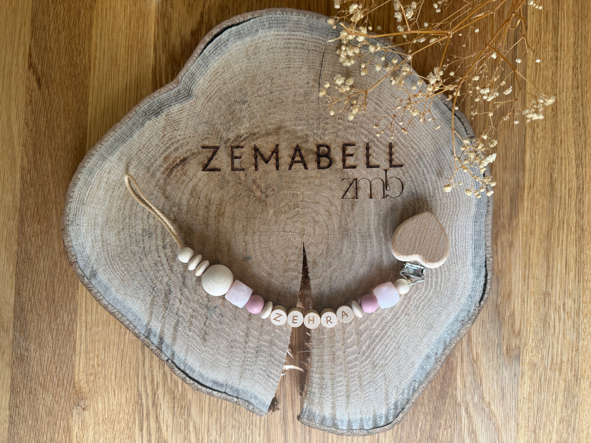 Personalisierbare Schnullerkette mit Holzbuchstaben und Herz, handgefertigt für Neugeborene.
